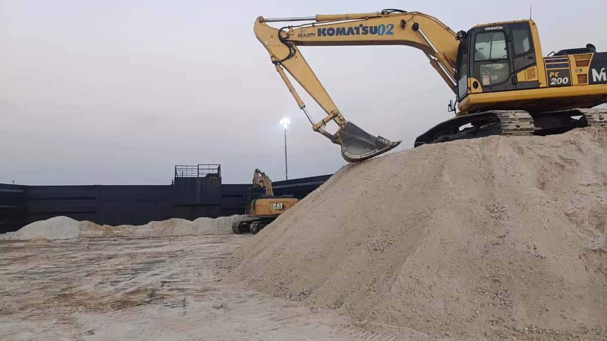 Excavator Komatsu di tumpukan material